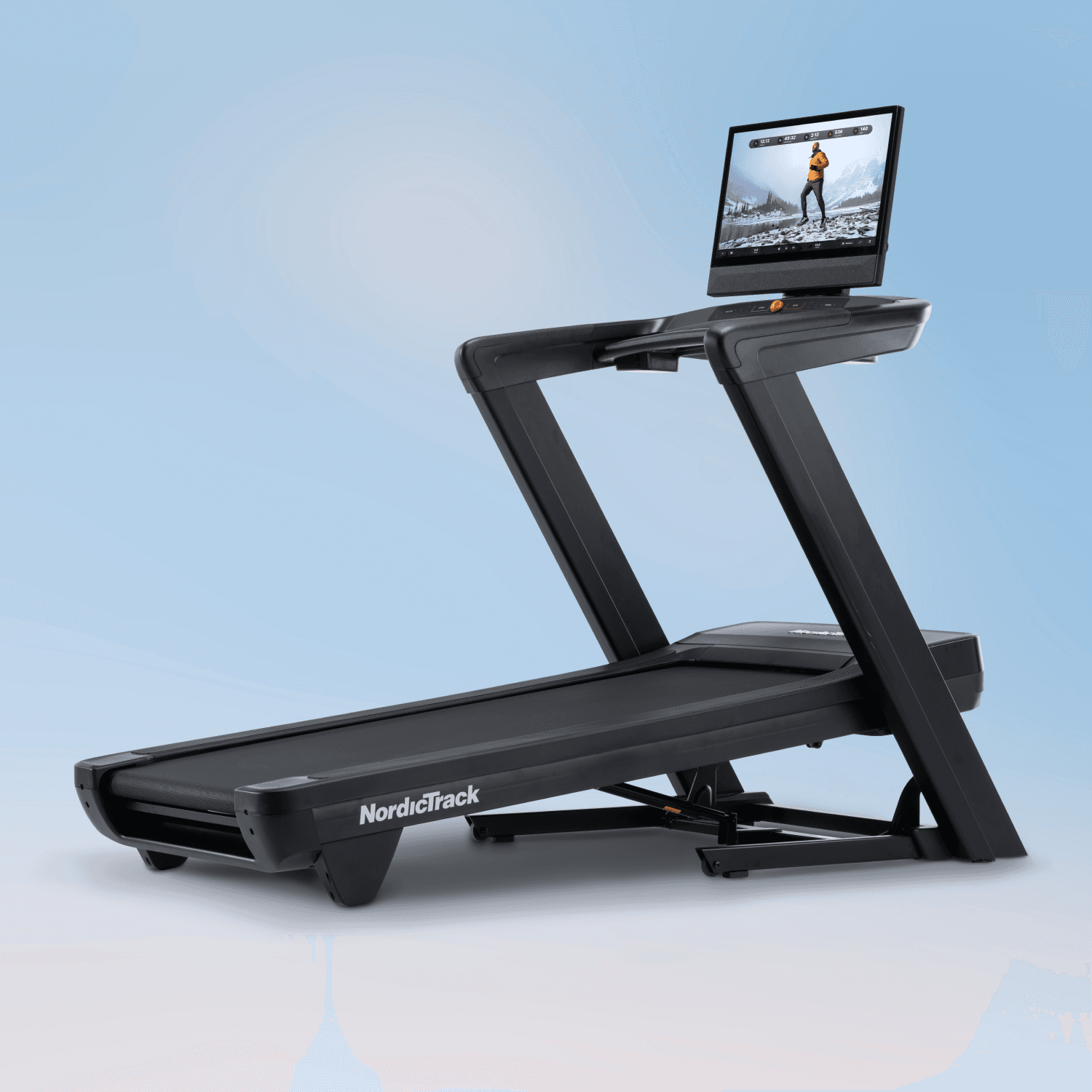 The Commercial 2450 Treadmill positioned at an incline on a blue backdrop showcasing winter workout content on its 24" touchscreen.
