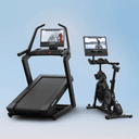 The Commercial 2450 Treadmill sitting side by side the X24 Studio Bike on a blue backdrop, featuring winter workouts on their touchscreens.